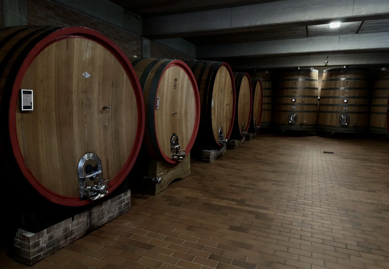 Grote houten fusten in de kelder van een producent in Piemonte